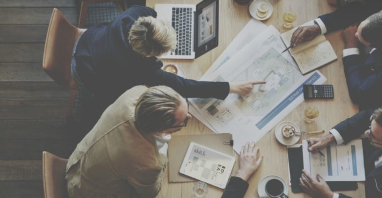 Employees sitting around a conference room desk