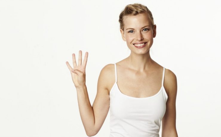Happy Woman Holding up Four Fingers