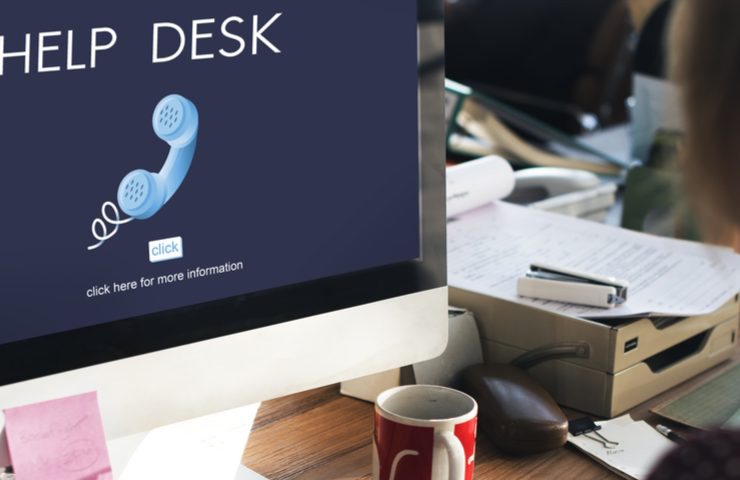 Person facing a computer screen that is displaying the words Help Desk and a phone icon