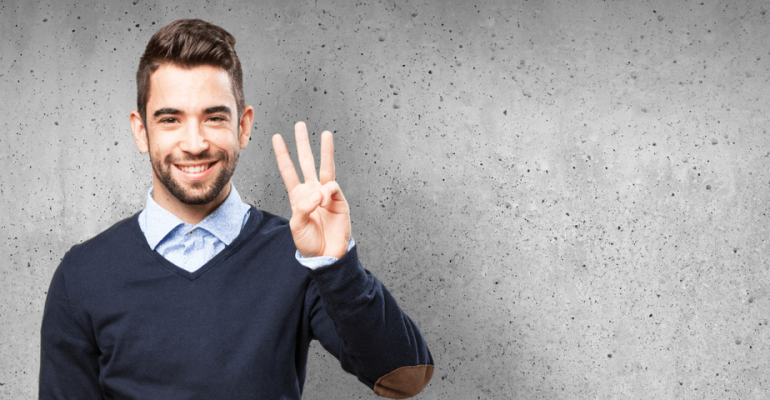 Young man smiling, holding up three fingers