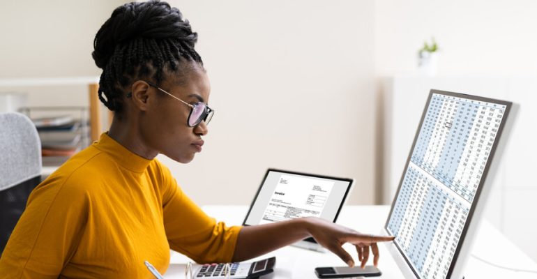 Young woman pointing at something on computer screen