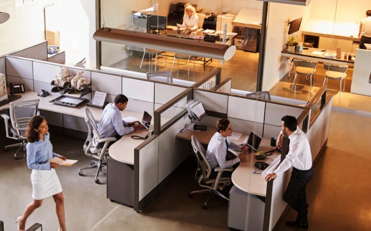 Busy office, with employees walking around and working at desks