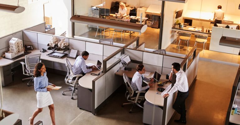 Busy office, with employees walking around and working at desks