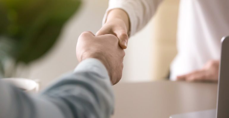 Two business employees shaking hands