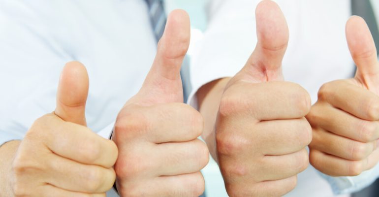 Close up of four hands in a row giving the thumbs up