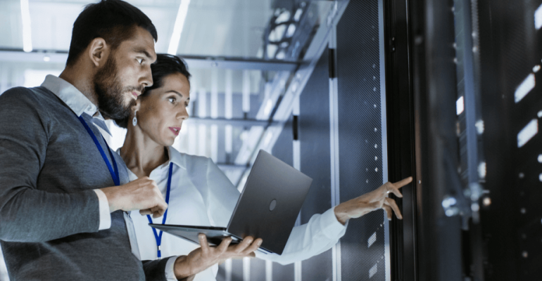 Two technicians in a data center hallway workng on a server
