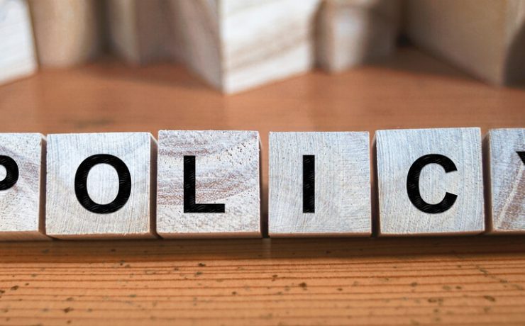 Wooden blocks spelling on the word policy on a wooden table