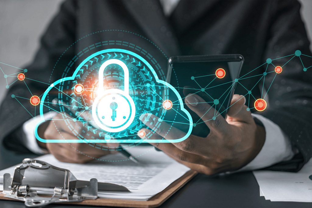 Close up of man in suit holding a smartphone and working on paperwork with a cloud security icon overlay