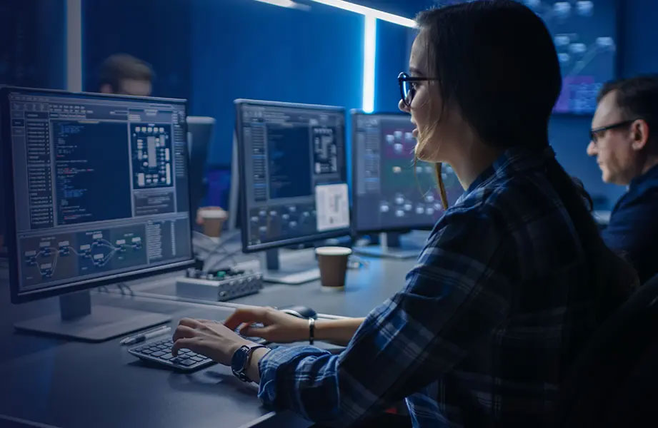 Side view of security monitoring technicians working on their computers