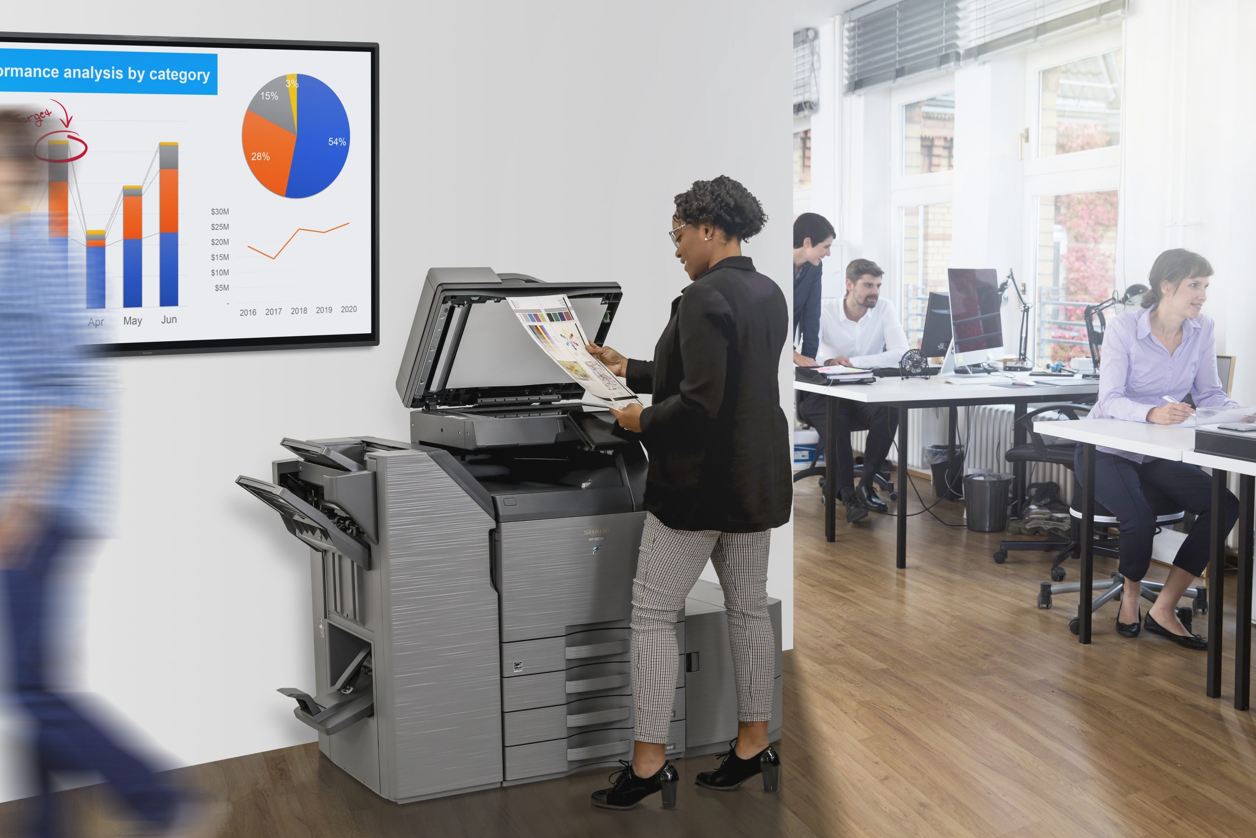 Lady standing at a multifunction printer scanning documents.