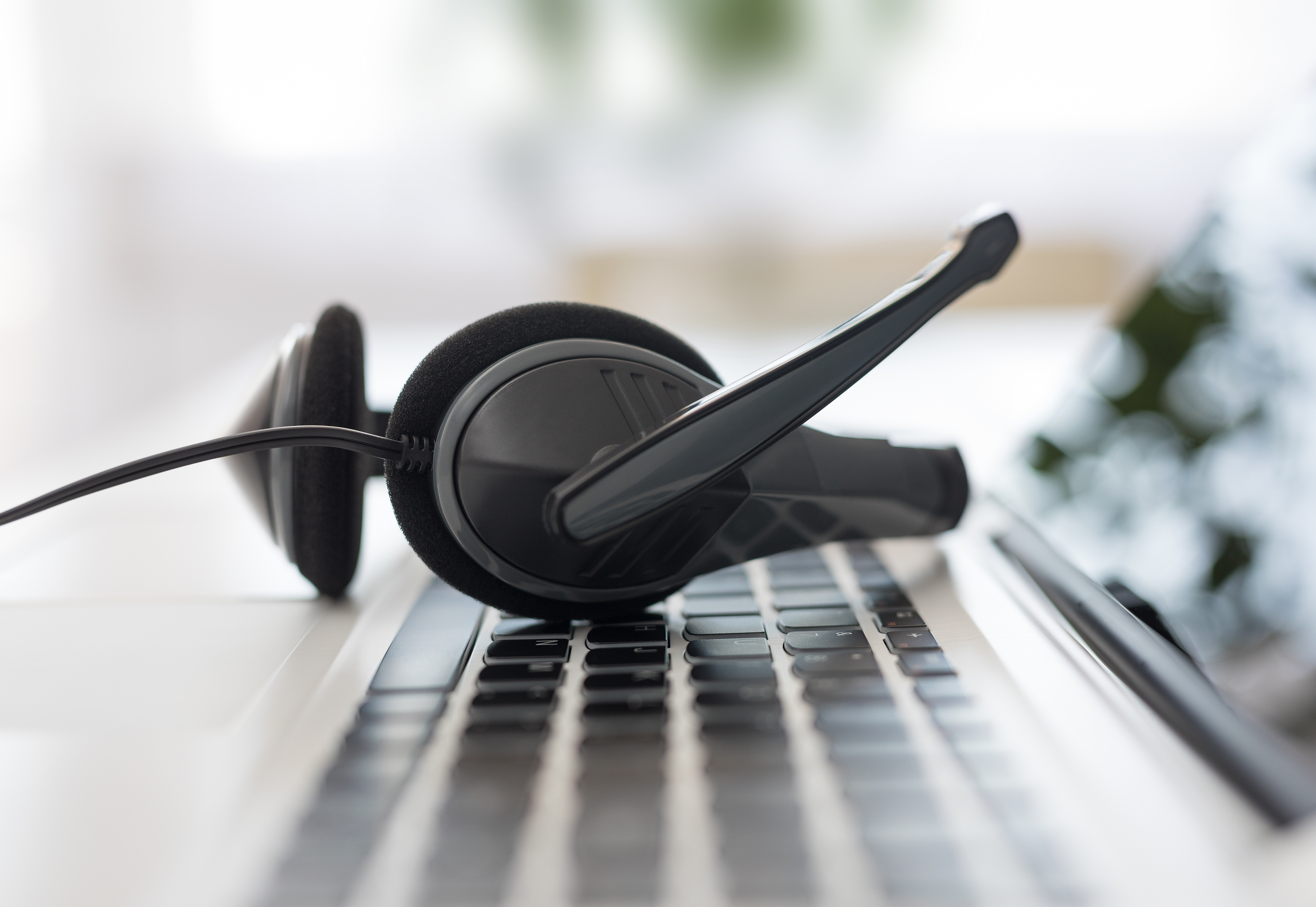Help desk headset on a laptop keyboard representing MMIT managed services support