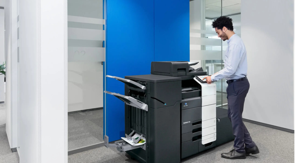 Business professional using an office copier while deciding whether to rent or buy equipment