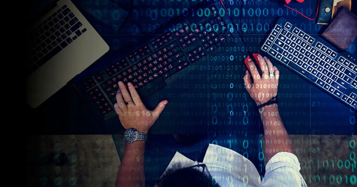 Person working at a computer with digital code overlay, representing how malware can enter business systems during everyday activity