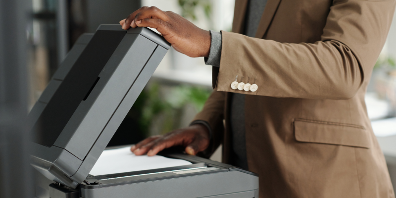 Office copier Office employee reviewing documents on a copier, showing signs of when to replace an office copier