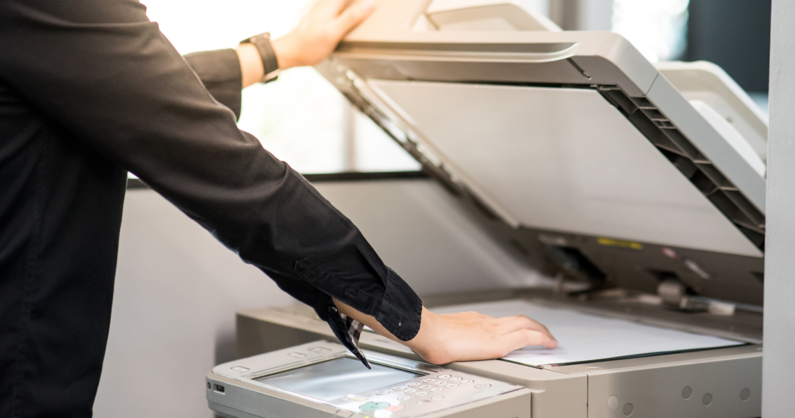 Office employee opening scanner lid on a multifunction printer to scan a document