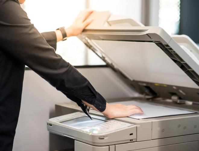 Office employee opening scanner lid on a multifunction printer to scan a document