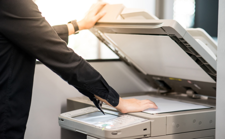 Office employee opening scanner lid on a multifunction printer to scan a document