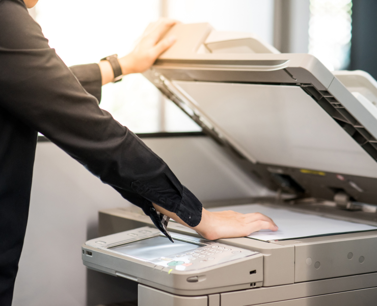 Office employee opening scanner lid on a multifunction printer to scan a document
